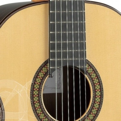 Violão acústico de madeira clara com seis cordas e roseta decorativa colorida