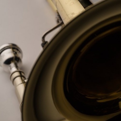 Trompete dourado com bocal prateado e decoração gravada