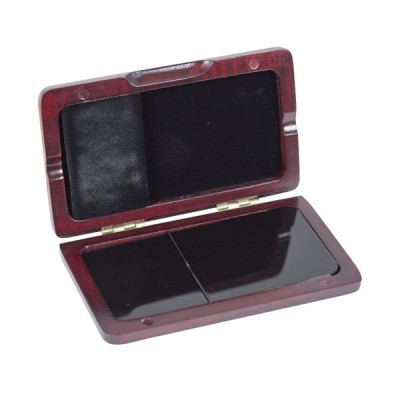 Estojo aberto em madeira com interior em veludo preto contendo duas pedras polidas pretas