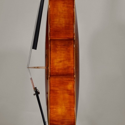 Violoncelo de madeira castanho-avermelhado com arco preto