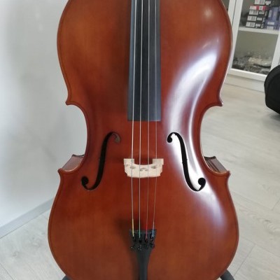 Violoncelo castanho claro com cordas num suporte tripé preto