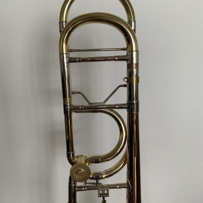 Trombone metálico dourado e prateado em fundo branco