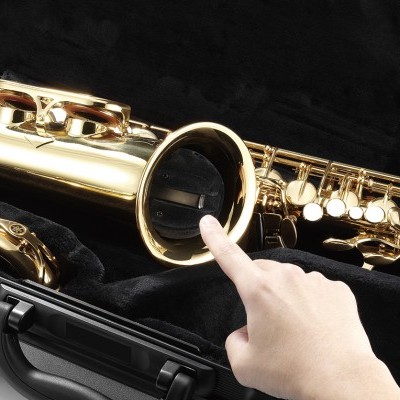 Saxofone dourado num estojo preto com mão a tocar o instrumento
