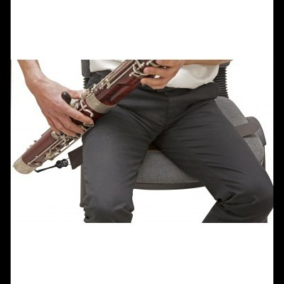 Pessoa sentada tocando fagote de madeira castanha com detalhes metálicos