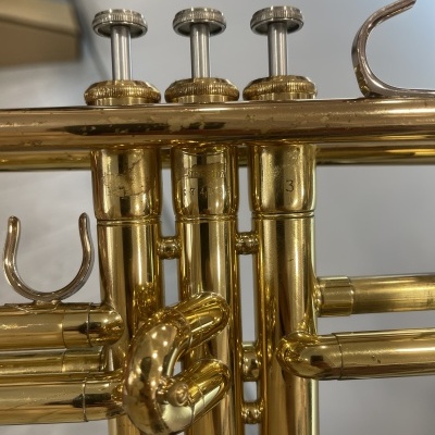 Trombete dourada com três válvulas numeradas 1, 2 e 3.