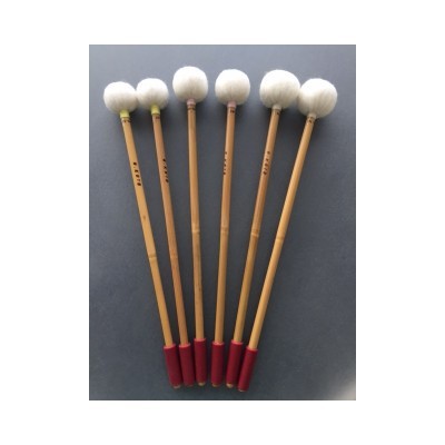 Seis baquetas de percussão com cabo de madeira e pontas de feltro branco em fundo cinzento