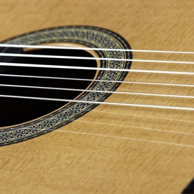 Guitarra acústica com tampo em madeira clara e cordas metálicas