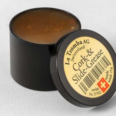 Frasco preto de graxa para rolamentos com rótulo redondo e tampa preta em fundo branco.