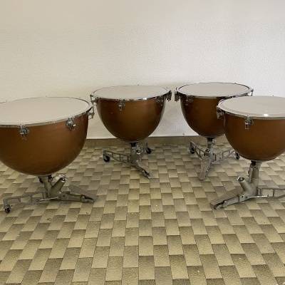 Conjunto de quatro tímpanos de madeira castanha com tripés metálicos