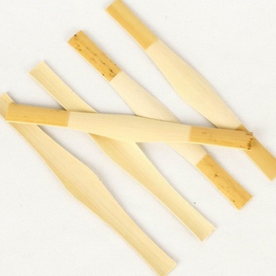 Conjunto de pás de madeira largas e estreitas, cores naturais, fundo branco.