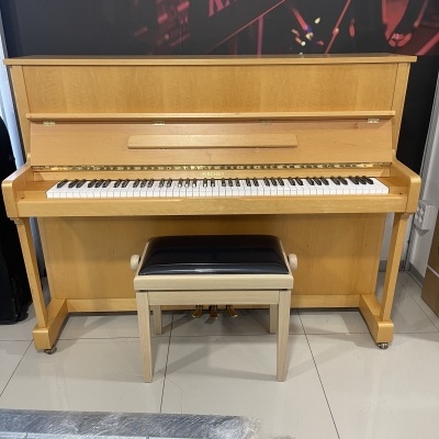 Piano vertical de madeira clara com banco em madeira clara e assento preto