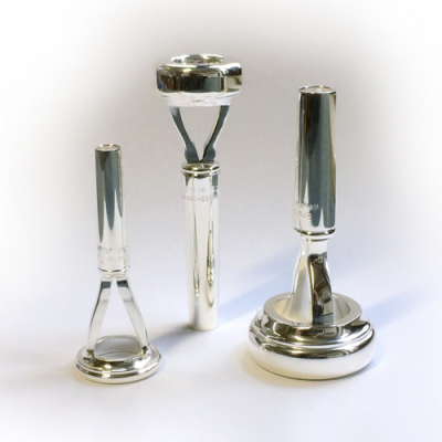 Três bocal de trompete de metal prateado em fundo branco