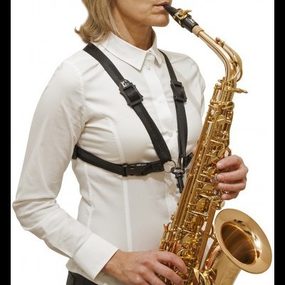 Pessoa a tocar saxofone alto com arnês de suporte preto