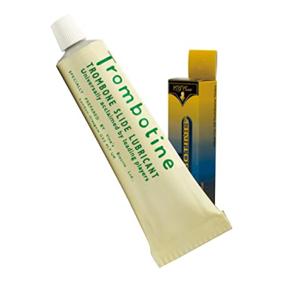 Tubo de lubrificante para trombone e sua embalagem ao lado, sobre fundo branco.