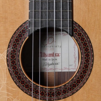 Guitarra clássica de madeira clara com colarinho decorativo e etiqueta interior visível