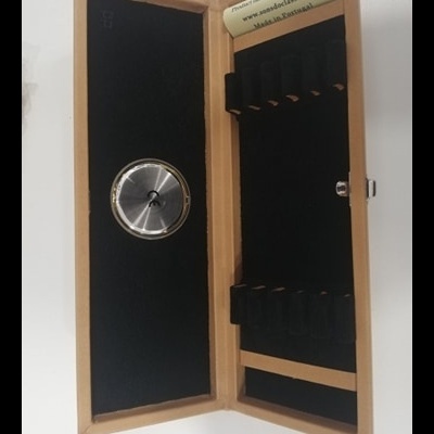 Estojo de madeira clara com interior preto e relógio de metal prateado