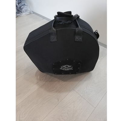 Mala preta hexagonal com alças sobre chão de madeira clara