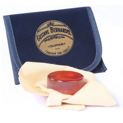Estojo azul com etiqueta GUSTAVE BERNARDEL e pastilha de resina âmbar sobre pano amarelo claro