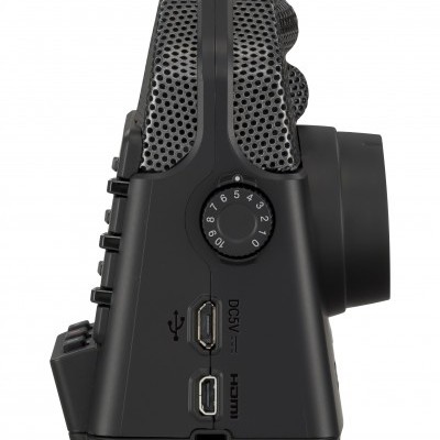 Gravador de áudio preto visto de lado com microfones de malha, mostrador numérico e portas USB e HDMI