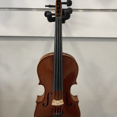 Violino de madeira castanha pendurado numa parede branca