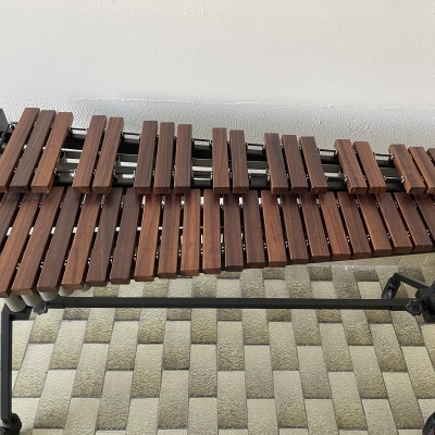 Marimba de madeira castanha com suporte metálico preto