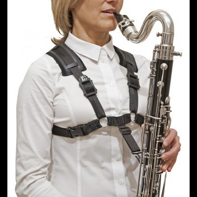 Pessoa com camisa branca e arnês preto a tocar fagote preto com detalhes metálicos prateados