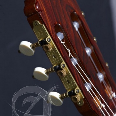 Cabeça de guitarra clássica em madeira vermelha com tarraxas douradas e botões brancos