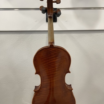 Violino castanho pendurado numa parede branca