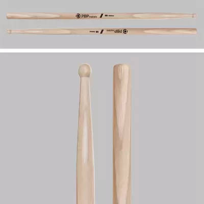 Baquetas de bateria em madeira clara com pontas diferentes numa superfície cinza
