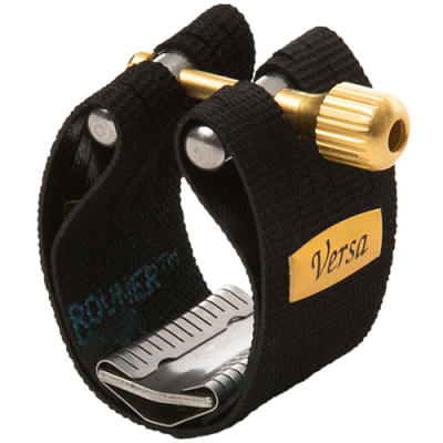 Clamp de corda com correia preta, peças metálicas douradas e prateadas, etiqueta amarela com texto Versa.