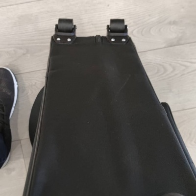 Mala de viagem preta vista da base com pés de borracha e fecho de correr