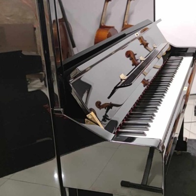 Piano vertical preto com acabamento espelhado e violinos refletidos na parede