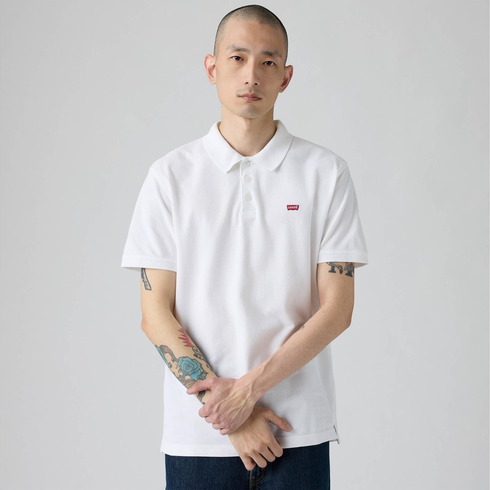 Polo Levi´s® New Housemark Branco de Manga Curta Homem a usar polo branco com logótipo LEVIS vermelho