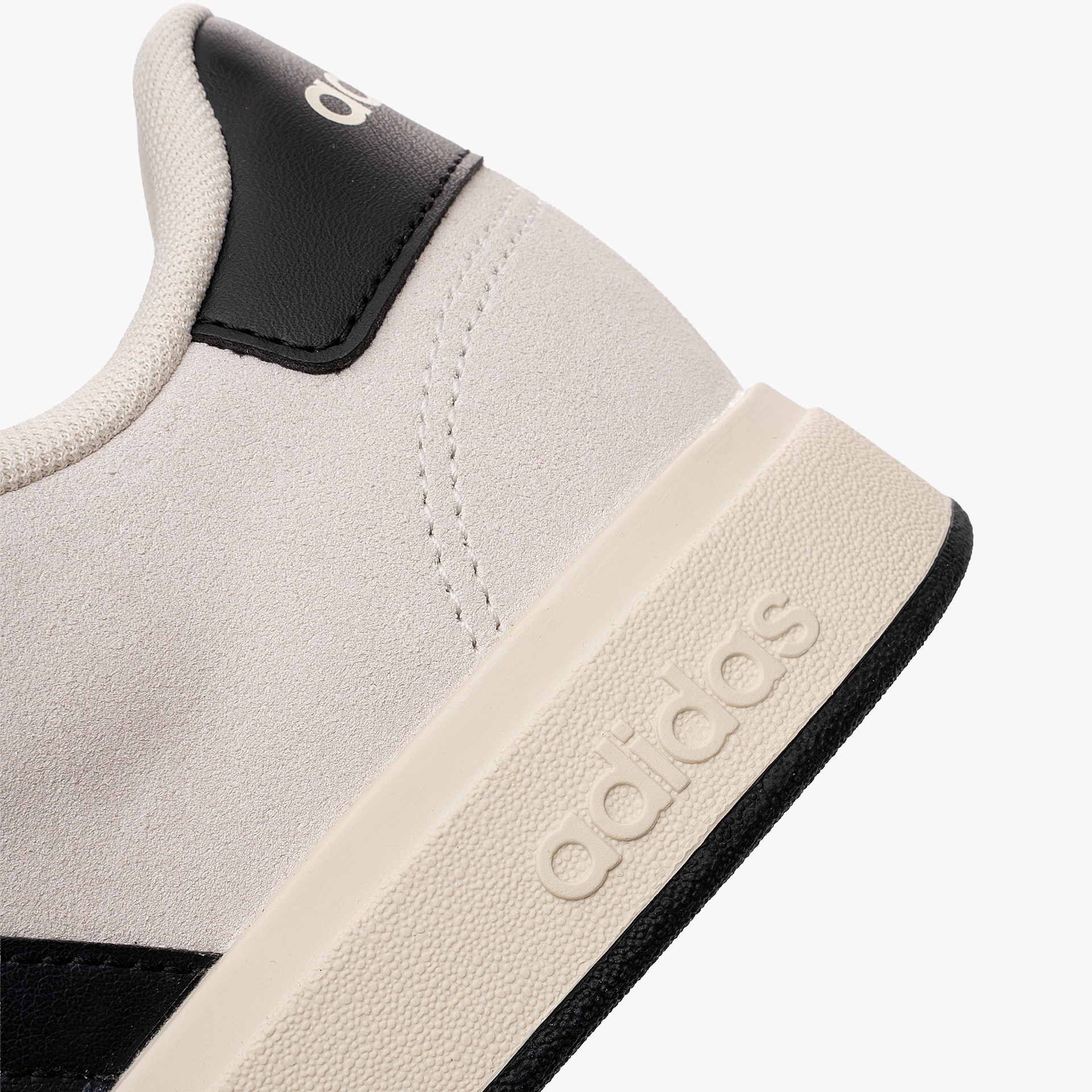 Sapatilhas Adidas Grand Court 00s Sapatilha Adidas bege e preta em detalhe próximo.
