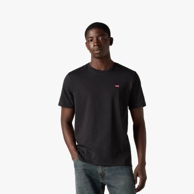 Homem vestindo t-shirt preta Levis com jeans azuis num fundo branco