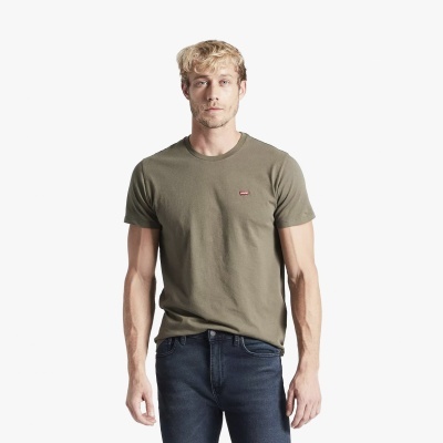 Homem com camisola verde oliva e jeans escuros