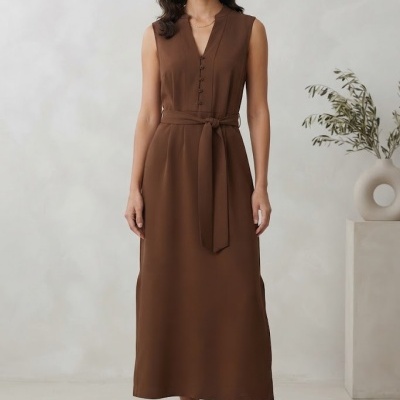 Vestido midi castanho sem mangas com cinto e botão, sandálias de salto alto.
