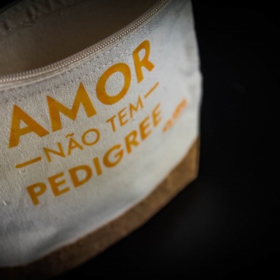 Bolsa ou necessaire branca com texto amarelo AMOR NÃO TEM PEDIGREE