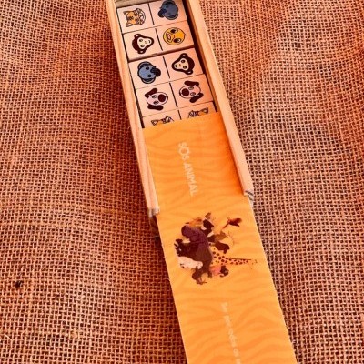 Caixa de madeira aberta com cubos ilustrados de animais em tecido rústico