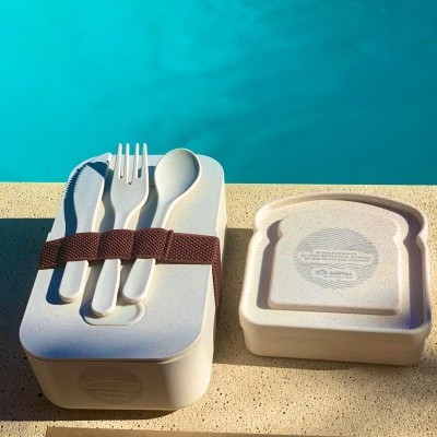 Conjunto de talheres reutilizáveis com caixa e tampa em fundo junto a piscina