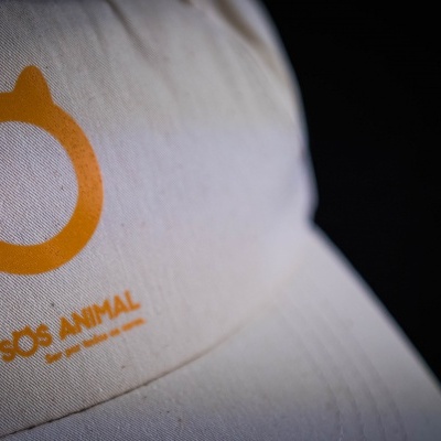 Boné branco com logo laranja e texto SOS ANIMAL