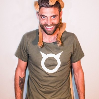 Homem com camiseta verde caqui e cão castanho no pescoço