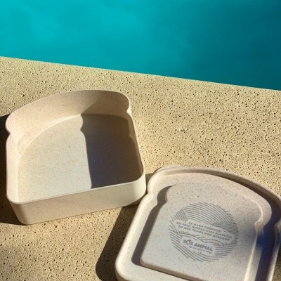 Conjunto recipiente e tampa formato fatia de pão cor bege com texto SOS ANIMAL.