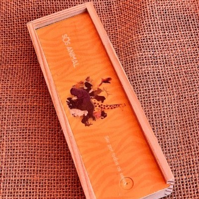 Caixa laranja com desenho de animais e texto SOS ANIMAL sobre tecido de juta