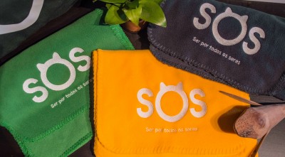 Toalhas coloridas com bordado branco e planta sobre superfície plana