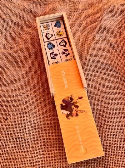 Caixa de madeira aberta com cubos ilustrados de animais em tecido rústico