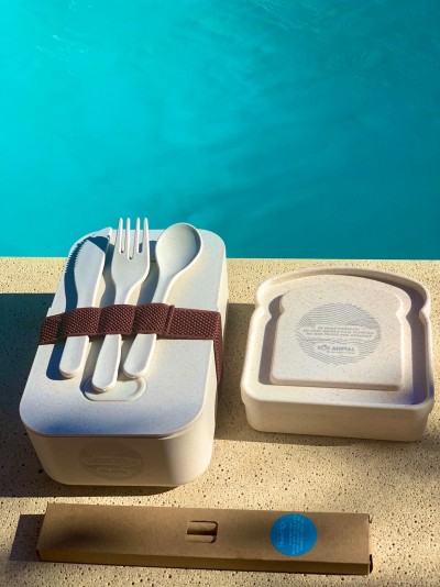 Conjunto de talheres reutilizáveis com caixa e tampa em fundo junto a piscina