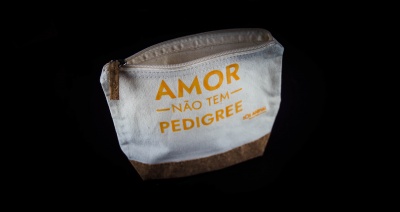 Bolsa pequena de tecido branco e castanho com texto em laranja