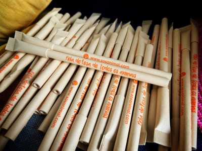 Pacotes de canudos biodegradáveis com texto laranja