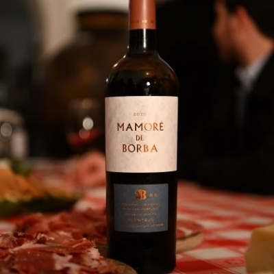 Garrafa de vinho Mamoré de Borba numa mesa com enchidos e queijo